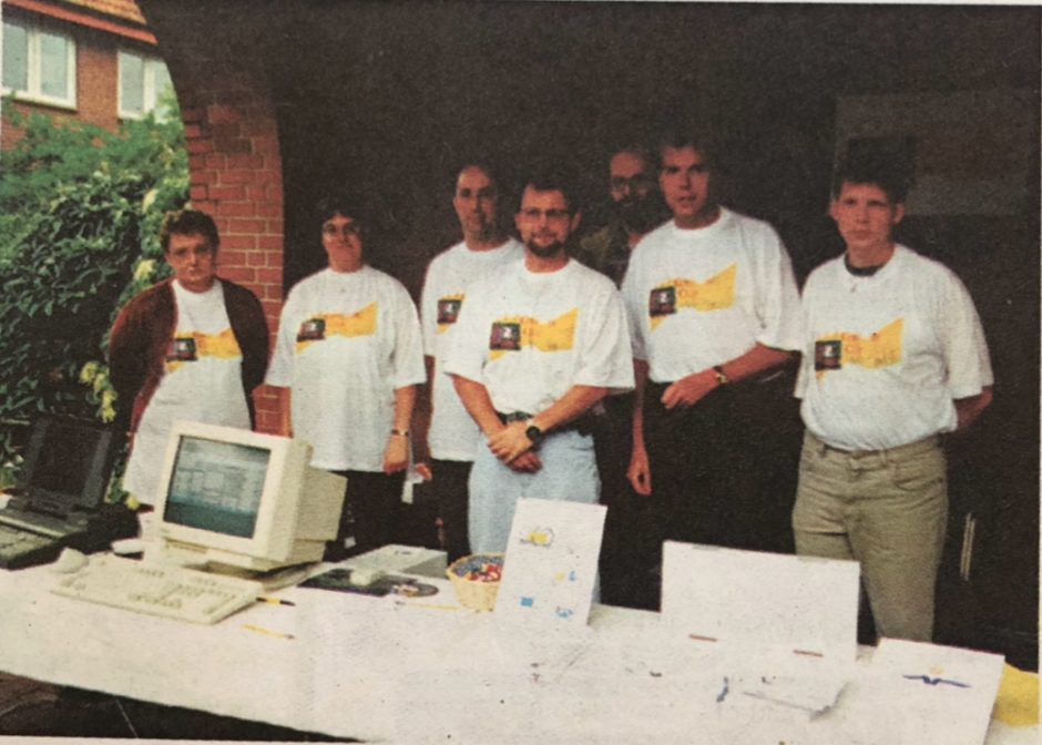 Gründungsmitglieder in Club-T-Shirts am Infostand 1998 mit einem Röhrenmonitor
